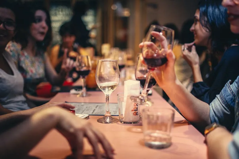 Friends sharing wine and conversation around a table at a tasting